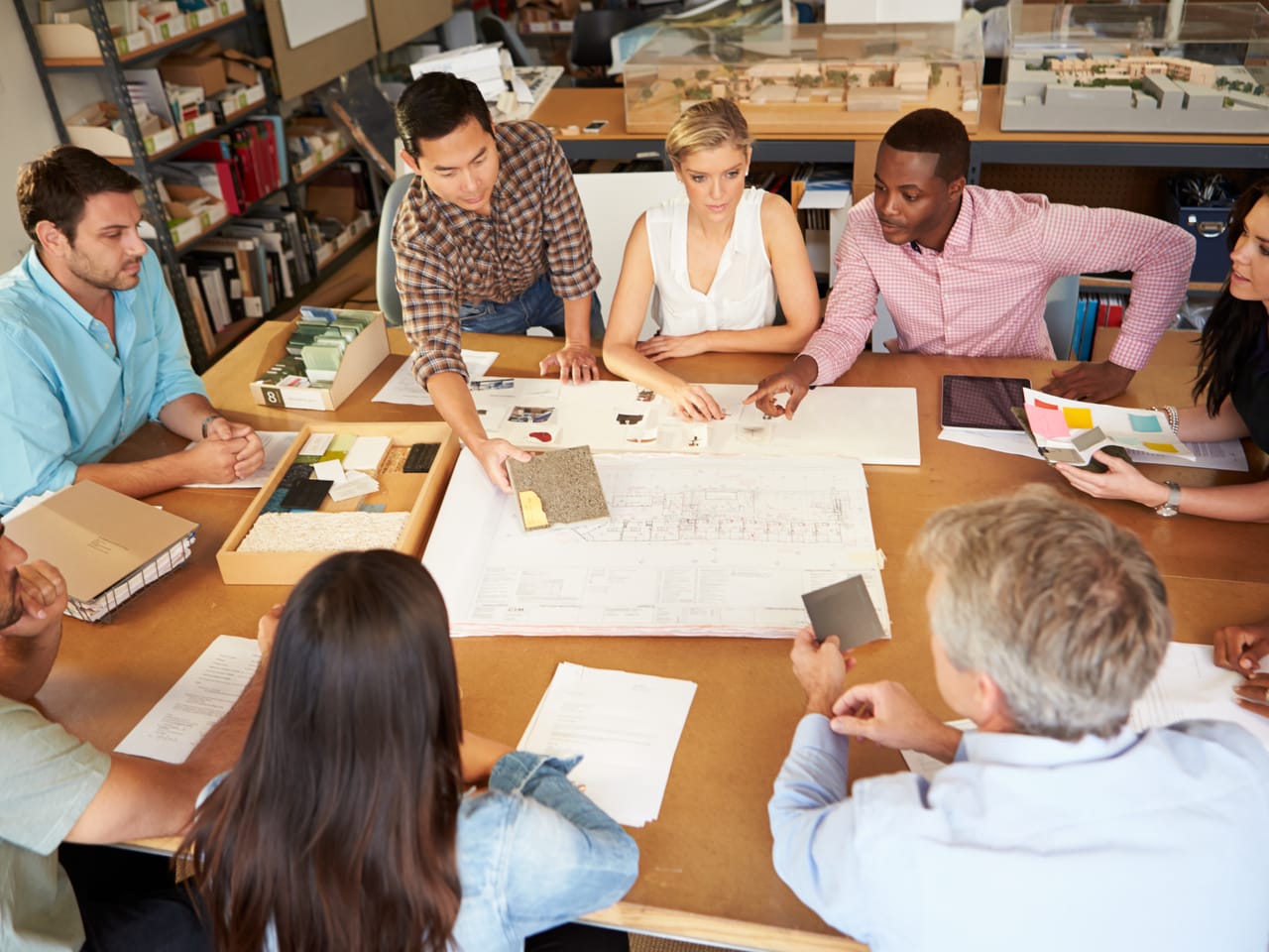 A team around a table reviewing plans and materials for a new project